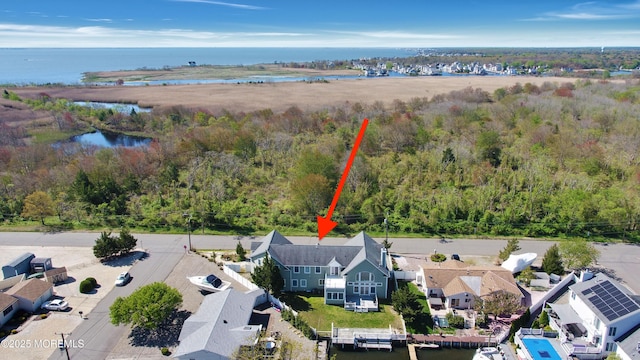 view of subject property featuring a nearby body of water and a forest