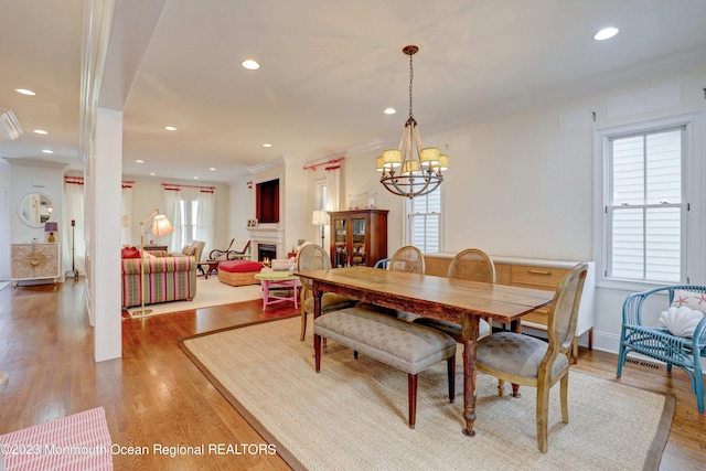 35 Embury Ave, Ocean Grove, NJ 07756 - dining room with a chandelier, recessed lighting, a lit fireplace, light wood-style floors, and ornamental molding