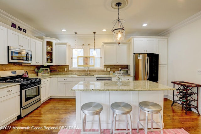 35 Embury Ave, Ocean Grove, NJ 07756 - kitchen with appliances with stainless steel finishes, a sink, crown molding, a center island, and a kitchen bar