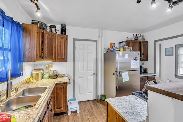 23 Vought Ave, Freehold, NJ 07728 - kitchen with freestanding refrigerator, a sink, decorative backsplash, light wood finished floors, and rail lighting