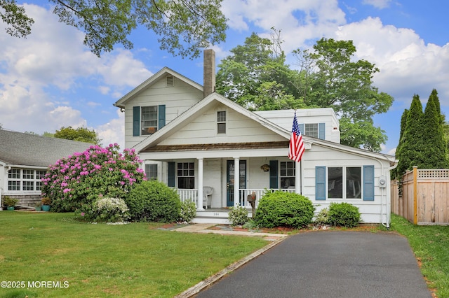 view of front of home featuring covered porch and a chimney