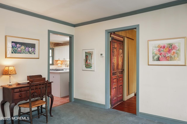 hallway with crown molding, carpet, and baseboards