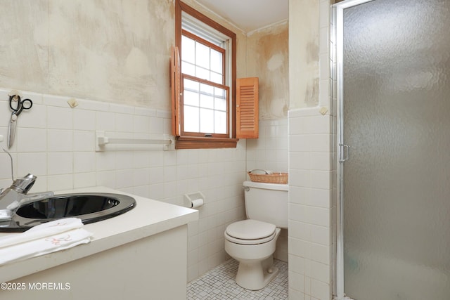 full bath featuring tile walls, a stall shower, toilet, vanity, and tile patterned flooring
