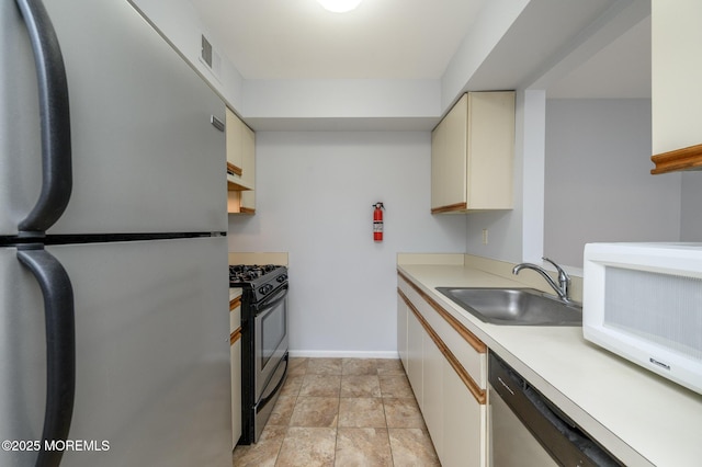 270 Main St Unit 6, Keansburg, NJ 07734 - kitchen featuring appliances with stainless steel finishes, a sink, cream cabinetry, light countertops, and baseboards
