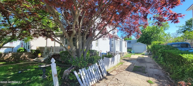 399 Willow Ave, Long Branch, NJ 07740 - view of side of home with a shed, an outbuilding, fence, concrete driveway, and stairs