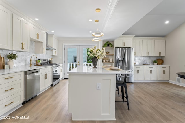 kitchen with stainless steel appliances, a sink, a kitchen bar, tasteful backsplash, and a center island