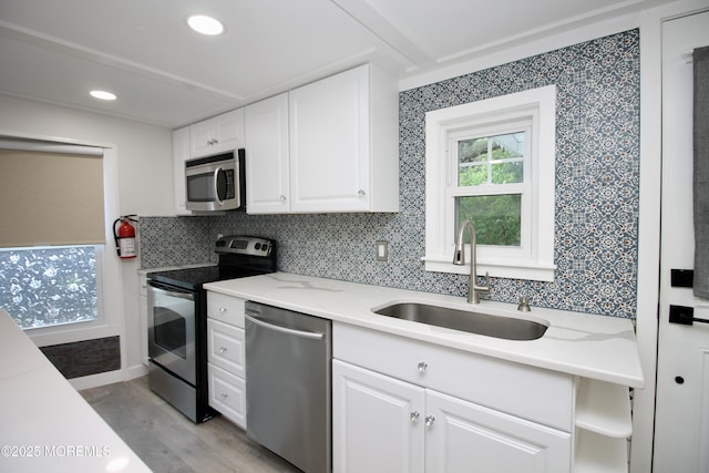 41 Eagle Dr, Whiting, NJ 08759 - kitchen with stainless steel appliances, a sink, white cabinetry, light wood-type flooring, and backsplash
