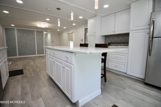 41 Eagle Dr, Whiting, NJ 08759 - kitchen featuring freestanding refrigerator, light wood-style floors, white cabinets, backsplash, and a center island