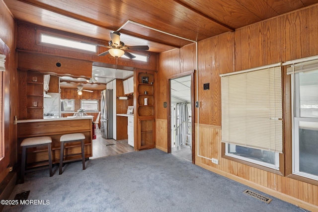 220 W Sylvania Ave Unit 16, Neptune City, NJ 07753 - kitchen with freestanding refrigerator, wood walls, ceiling fan, carpet flooring, and a peninsula
