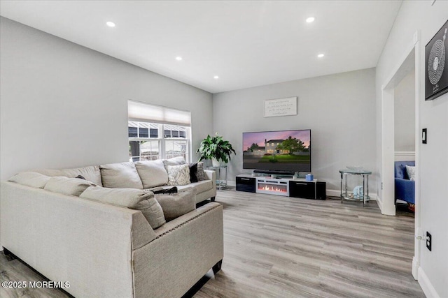 living room featuring wood finished floors, recessed lighting, and baseboards