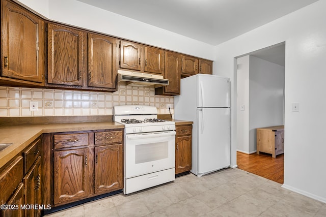 32 Bugle Ct, Toms River, NJ 08757 - kitchen featuring white appliances, under cabinet range hood, tasteful backsplash, and baseboards