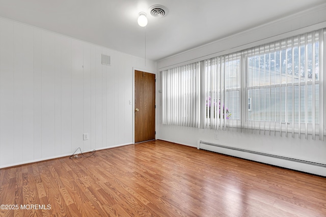 32 Bugle Ct, Toms River, NJ 08757 - spare room with a baseboard heating unit, wood finished floors, and healthy amount of natural light