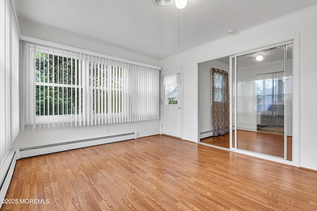 32 Bugle Ct, Toms River, NJ 08757 - empty room with a baseboard radiator, ornamental molding, wood finished floors, and healthy amount of natural light