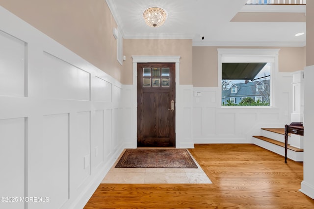 3 Sunset Dr, Asbury Park, NJ 07712 - entrance foyer with a decorative wall, light wood-type flooring, wainscoting, a chandelier, and ornamental molding