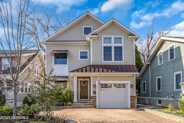 3 Sunset Dr, Asbury Park, NJ 07712 - view of front of property featuring a standing seam roof, stone siding, decorative driveway, an attached garage, and metal roof