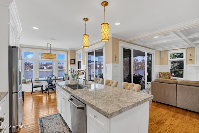 3 Sunset Dr, Asbury Park, NJ 07712 - kitchen with a sink, appliances with stainless steel finishes, light wood-type flooring, an island with sink, and a wainscoted wall