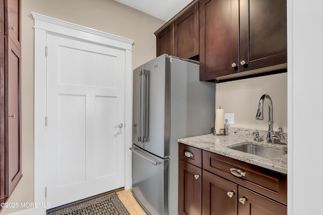 3 Sunset Dr, Asbury Park, NJ 07712 - kitchen featuring a sink, high quality fridge, light stone counters, dark brown cabinetry, and light tile patterned flooring
