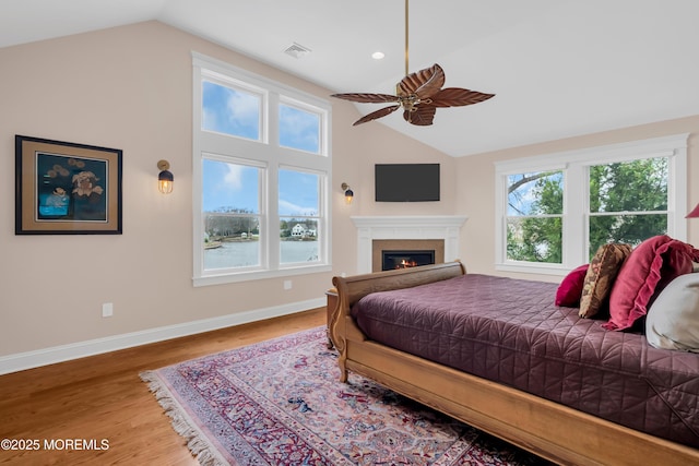 3 Sunset Dr, Asbury Park, NJ 07712 - bedroom with vaulted ceiling, wood finished floors, baseboards, a warm lit fireplace, and ceiling fan