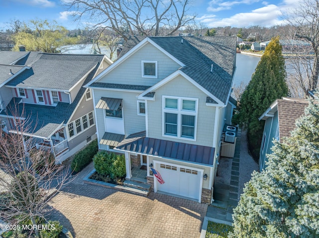 3 Sunset Dr, Asbury Park, NJ 07712 - view of front facade with a standing seam roof, roof with shingles, a garage, stone siding, and metal roof