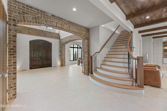 1 Preakness Way, Colts Neck, NJ 07722 - foyer with arched walkways, brick wall, stairway, beam ceiling, and recessed lighting