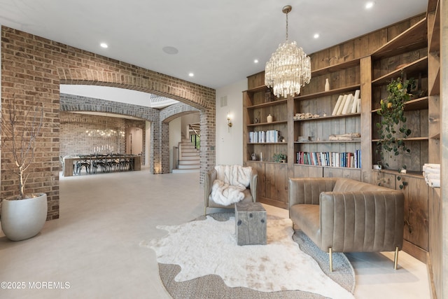 1 Preakness Way, Colts Neck, NJ 07722 - sitting room with arched walkways, brick wall, a chandelier, built in features, and recessed lighting