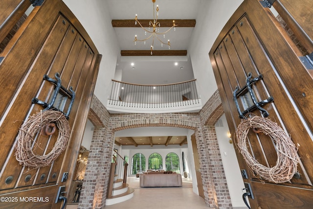 1 Preakness Way, Colts Neck, NJ 07722 - entryway with beamed ceiling, a high ceiling, a chandelier, arched walkways, and stairs