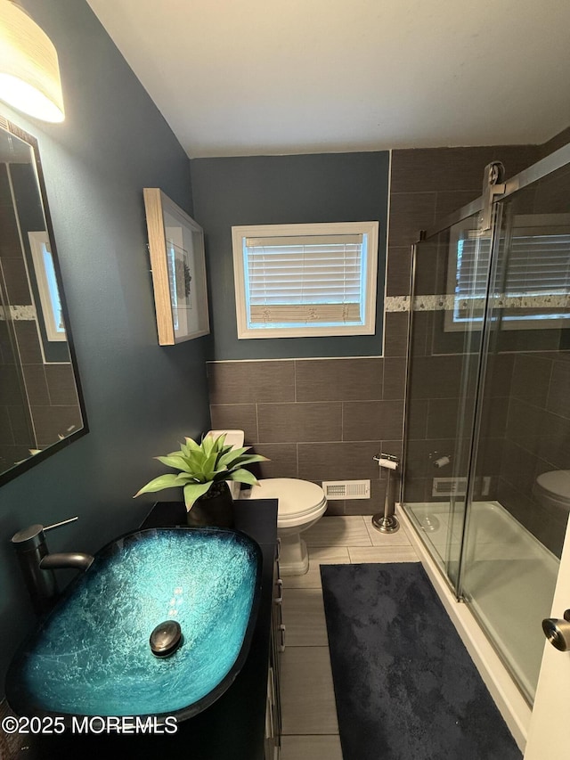 full bath with toilet, a shower stall, tile patterned flooring, and vanity