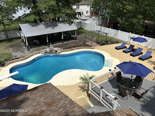view of swimming pool with a wooden deck, a fenced backyard, outdoor dining area, and a patio
