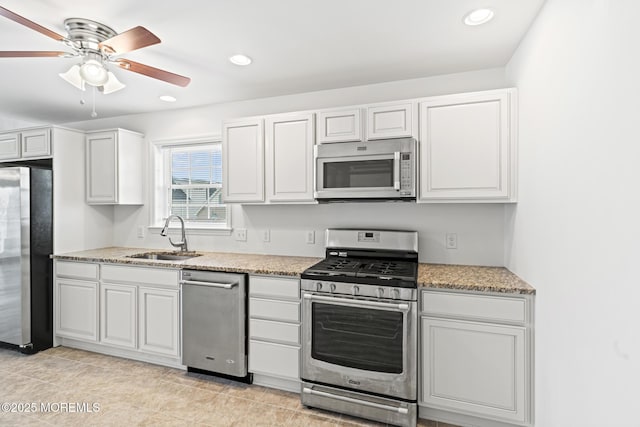 1707 Bay Blvd Unit 4, Seaside Heights, NJ 08751 - kitchen featuring appliances with stainless steel finishes, a sink, a ceiling fan, white cabinets, and light stone counters