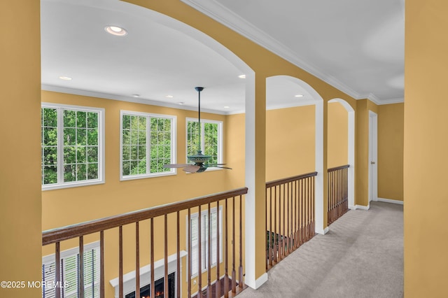 hall featuring carpet floors, baseboards, ornamental molding, recessed lighting, and arched walkways