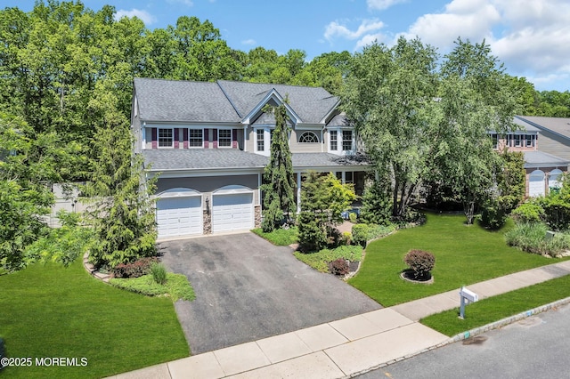 view of front facade with asphalt driveway, an attached garage, a front lawn, roof with shingles, and stone siding