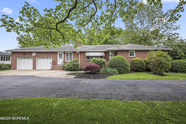 624 Lloyd Rd, Aberdeen, NJ 07747 - ranch-style house with a garage, concrete driveway, brick siding, and a chimney