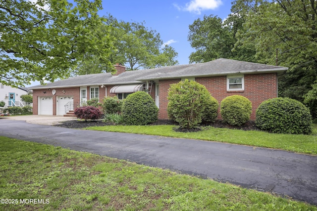 624 Lloyd Rd, Aberdeen, NJ 07747 - single story home with brick siding, a garage, a chimney, driveway, and a front lawn