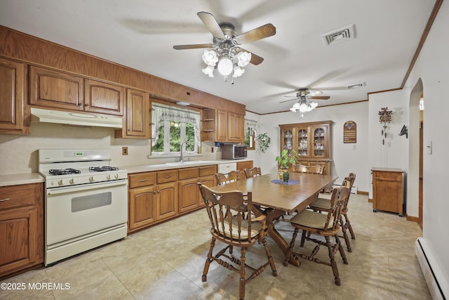 624 Lloyd Rd, Aberdeen, NJ 07747 - kitchen with gas range gas stove, under cabinet range hood, baseboard heating, a sink, and brown cabinets