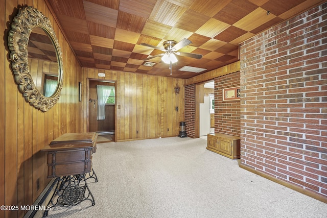 624 Lloyd Rd, Aberdeen, NJ 07747 - carpeted empty room with wooden ceiling, ceiling fan, wooden walls, and brick wall