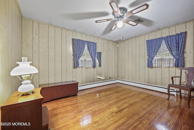624 Lloyd Rd, Aberdeen, NJ 07747 - sitting room featuring ceiling fan, wood finished floors, a baseboard heating unit, and wood walls