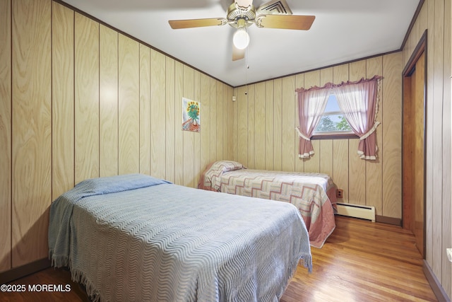 624 Lloyd Rd, Aberdeen, NJ 07747 - bedroom with a baseboard radiator, wood finished floors, a ceiling fan, wood walls, and baseboards