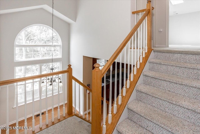 24 Hanna Ln Unit 304, Laurence Harbor, NJ 08879 - stairway with a chandelier, a towering ceiling, and wood finished floors
