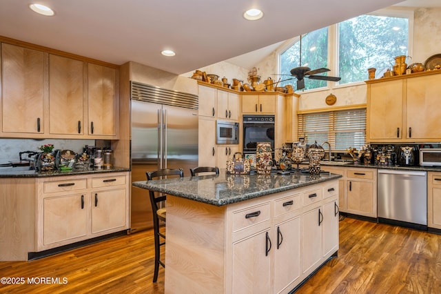 5 Stone Ln, Marlboro, NJ 07746 - kitchen featuring built in appliances, dark wood-style floors, light brown cabinets, lofted ceiling, and a breakfast bar area