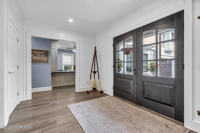 entryway featuring wood finished floors, baseboards, french doors, crown molding, and a ceiling fan