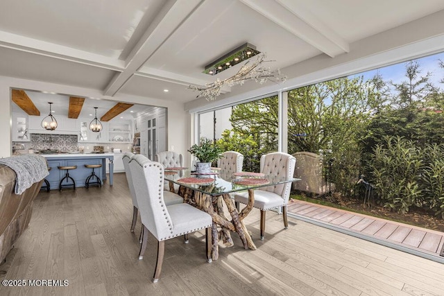 dining room with beam ceiling, wood finished floors, and a chandelier