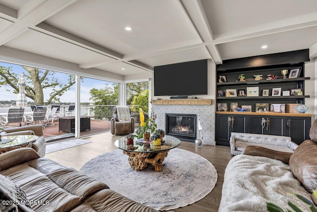 living area featuring coffered ceiling, a tile fireplace, beamed ceiling, wood finished floors, and recessed lighting