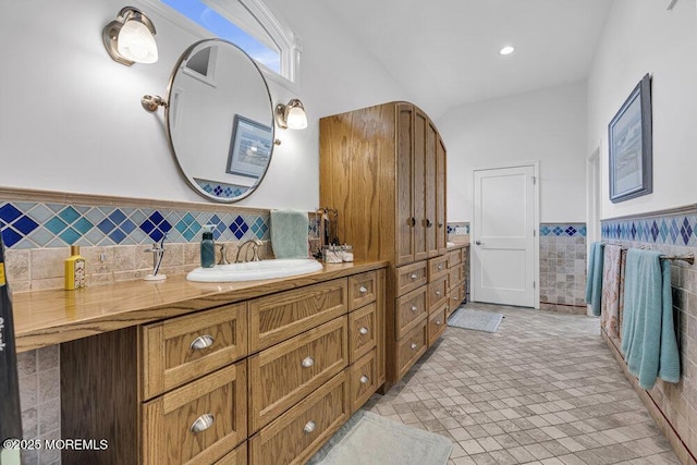 bathroom with tile walls, wainscoting, vanity, and tile patterned floors