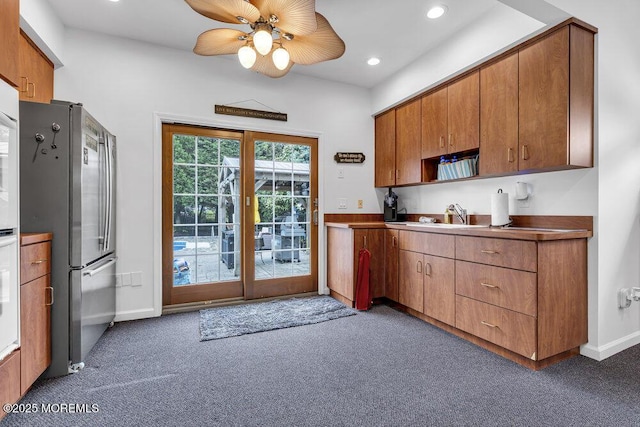 kitchen featuring freestanding refrigerator, carpet floors, a ceiling fan, a sink, and recessed lighting