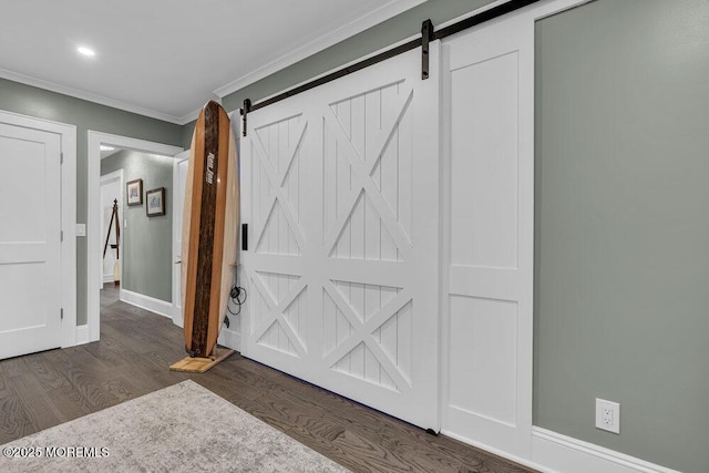 entrance foyer with a barn door, crown molding, dark wood finished floors, baseboards, and recessed lighting