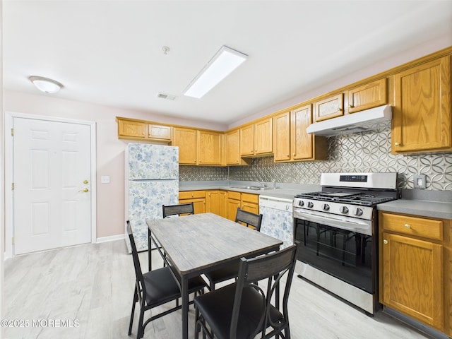 183 Liddle Ave, Edison, NJ 08837 - kitchen featuring stainless steel range with gas cooktop, under cabinet range hood, freestanding refrigerator, a sink, and backsplash