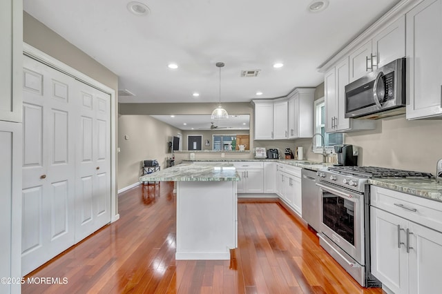 14 Santiago Dr W, Toms River, NJ 08757 - kitchen with stainless steel appliances, a sink, white cabinetry, a peninsula, and light stone countertops