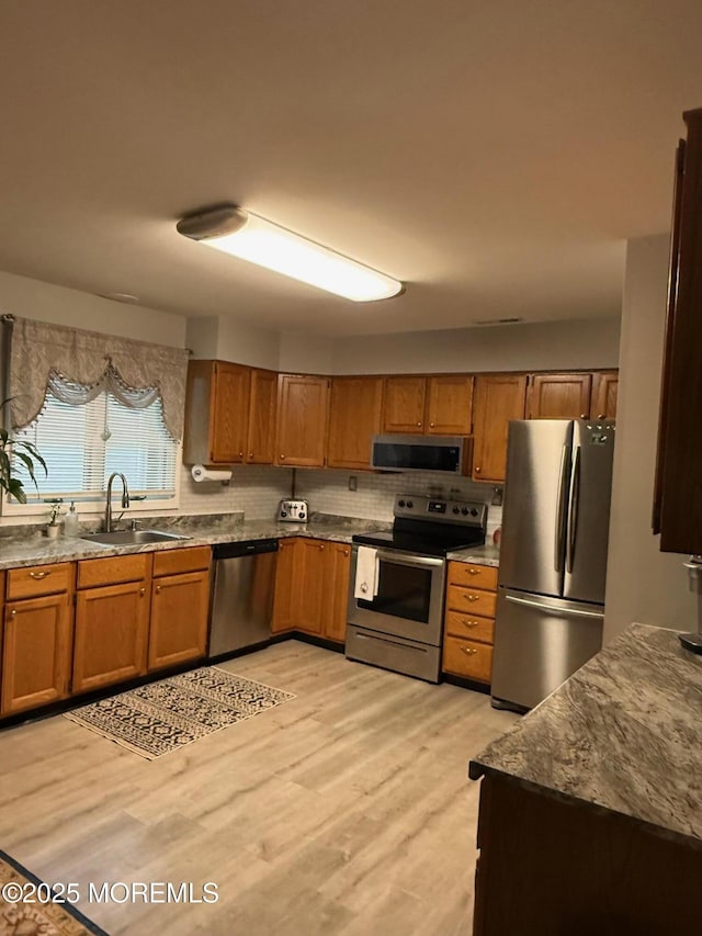 4 Capewoods Rd, North Cape May, NJ 08204 - kitchen featuring appliances with stainless steel finishes, a sink, brown cabinets, and light wood-type flooring