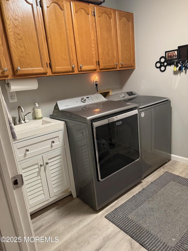 4 Capewoods Rd, North Cape May, NJ 08204 - laundry room with washing machine and dryer, cabinet space, light wood finished floors, and baseboards