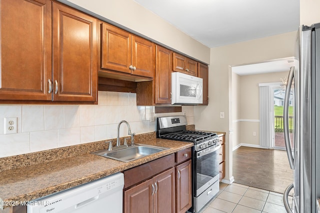 7 Sloop Sq, Freehold, NJ 07728 - kitchen with appliances with stainless steel finishes, a sink, light tile patterned floors, baseboards, and decorative backsplash